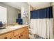 Bathroom featuring a single sink vanity, beige tile accents, toilet, and a shower with curtain at 3227 Aviary Nw Ct, Acworth, GA 30101