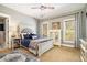 Bedroom with a tufted headboard bed, plush carpet, two windows and bedside tables at 3227 Aviary Nw Ct, Acworth, GA 30101