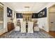 Elegant dining room boasts wainscoting, navy accent wall, a modern chandelier, and a large window at 3227 Aviary Nw Ct, Acworth, GA 30101