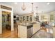 Open kitchen featuring granite countertops, stainless steel appliances, and an island adjacent to the dining and living area at 3227 Aviary Nw Ct, Acworth, GA 30101