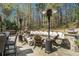 Outdoor lounge area with a stone seating wall, a fire pit, patio heaters and wooded view at 3227 Aviary Nw Ct, Acworth, GA 30101