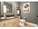 Stylish powder room featuring a granite countertop, framed mirror, and elegant decor at 3227 Aviary Nw Ct, Acworth, GA 30101