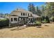 Wide view of the rear exterior of the home, featuring a patio, fire pit, outdoor kitchen and screened in porch at 3227 Aviary Nw Ct, Acworth, GA 30101