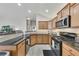Bright kitchen featuring wooden cabinets, dark granite countertops, tiled backsplash, and stainless steel appliances at 4927 Magnolia Cottage Way, Acworth, GA 30101