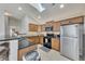 Bright kitchen featuring wood cabinetry, granite counters, stainless appliances and a skylight at 4927 Magnolia Cottage Way, Acworth, GA 30101