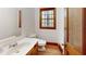 Powder room features a toilet, sink with vanity, wood trim, and a window providing natural light at 993 Castle Falls Dr. Ne Dr, Atlanta, GA 30329