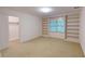 Carpeted bedroom featuring built-in shelving and window with natural light at 993 Castle Falls Dr. Ne Dr, Atlanta, GA 30329
