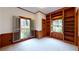 Bright office space featuring a wall of built-in shelves and large windows with views of the landscaped yard at 993 Castle Falls Dr. Ne Dr, Atlanta, GA 30329