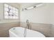 Bright bathroom featuring a standalone tub with elegant fixtures and a decorative stained-glass window at 108 Kirk Crossing Dr, Decatur, GA 30030