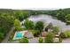 Aerial view of community with a lake, pool, playground, and multiple homes surrounded by lush greenery at 132 Lakeshore Dr, Roswell, GA 30075