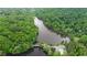 Picturesque aerial view of a community bordering a lake and lush green forest with a swimming pool at 132 Lakeshore Dr, Roswell, GA 30075