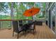 Back deck area with an outdoor dining table, umbrella, overlooking the lake, and black metal railing at 132 Lakeshore Dr, Roswell, GA 30075