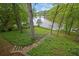 View of the backyard with stone stairs leading to a scenic lake surrounded by lush greenery at 132 Lakeshore Dr, Roswell, GA 30075
