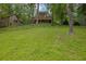 Lush green lawn, and a deck featuring an orange umbrella, overlooking a serene backyard at 132 Lakeshore Dr, Roswell, GA 30075