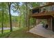 Scenic backyard featuring a covered patio, steps to the lake, and mature trees providing privacy and shade at 132 Lakeshore Dr, Roswell, GA 30075