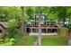 Contemporary two-story home with large windows and spacious deck surrounded by lush greenery and mature trees at 132 Lakeshore Dr, Roswell, GA 30075
