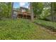 Contemporary two-story home with a spacious deck, surrounded by lush greenery with stone steps leading to the house at 132 Lakeshore Dr, Roswell, GA 30075