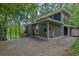 Contemporary home nestled among trees, featuring a gravel driveway, with lake view and an outdoor shed at 132 Lakeshore Dr, Roswell, GA 30075