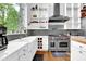 Bright kitchen featuring a farm sink, stainless steel appliances, white cabinets, and a window with lush outdoor views at 132 Lakeshore Dr, Roswell, GA 30075