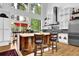 Bright kitchen with a wood-finished island, stainless steel appliances, white cabinetry, and expansive windows overlooking outdoor scenery at 132 Lakeshore Dr, Roswell, GA 30075