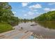 Picturesque lake view with a wooden dock, surrounded by lush trees and clear blue skies at 132 Lakeshore Dr, Roswell, GA 30075