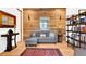 Inviting living room showcasing a modern gray sofa, accent rug, and a rustic wood plank wall with stylish light fixtures at 132 Lakeshore Dr, Roswell, GA 30075