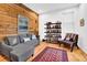 Comfortable living room with a stylish gray sectional sofa, wooden accent wall, and a well-stocked bookshelf, perfect for relaxing at 132 Lakeshore Dr, Roswell, GA 30075