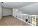 Carpeted loft featuring a white railing that overlooks the living room and a door to the side at 207 Bridge Se Ln, Smyrna, GA 30082