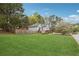 Large green backyard featuring a fenced perimeter, mature trees, and a charming home exterior at 21 Enclave Walk, Powder Springs, GA 30127