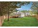 A large backyard featuring mature trees, green lawn, and wood privacy fence at 21 Enclave Walk, Powder Springs, GA 30127