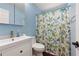 Well-lit bathroom with a white vanity and a shower-tub combination with modern shower curtain at 21 Enclave Walk, Powder Springs, GA 30127