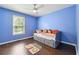 Cheerful bedroom with bright blue walls and natural light from a large window at 21 Enclave Walk, Powder Springs, GA 30127