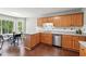 Eat-in kitchen features wood cabinets, stainless steel appliances, and backyard views at 21 Enclave Walk, Powder Springs, GA 30127
