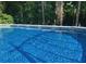 Close-up of a sparkling above ground pool with crystal clear water, surrounded by lush greenery at 21 Enclave Walk, Powder Springs, GA 30127