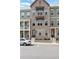 A three-story townhome with brick facade and steps leading to the front door at 308 Overture Ct, Smyrna, GA 30080