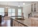 Bright kitchen featuring an island with a granite countertop and a sink, open to a game room with a pool table at 308 Overture Ct, Smyrna, GA 30080