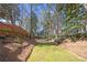 Tranquil backyard ravine features verdant grass flanked by mature trees, creating a serene natural border for the property at 3285 Millwood Se Trl, Smyrna, GA 30080