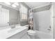Clean white bathroom with combined tub and shower, window, vanity and white ceramic tile at 3285 Millwood Se Trl, Smyrna, GA 30080