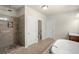 Lovely bathroom features glass shower and soaking tub with modern fixtures and finishes at 11620 Crestview Ter, Johns Creek, GA 30024