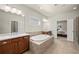 Bright bathroom features double vanity, soaking tub, tile floor, and access to bedroom at 11620 Crestview Ter, Johns Creek, GA 30024