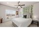 Cozy bedroom with a comfortable bed, a large window with blinds, and decorative greenery at 11620 Crestview Ter, Johns Creek, GA 30024