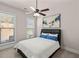 A cozy bedroom features a modern ceiling fan, neutral walls, and bright, natural light from two windows at 11620 Crestview Ter, Johns Creek, GA 30024