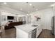 A modern kitchen that opens up to the living room, with a center island and stainless appliances at 11620 Crestview Ter, Johns Creek, GA 30024