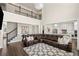 A spacious living room features dark hardwood floors, a large sectional, and a view into the kitchen at 11620 Crestview Ter, Johns Creek, GA 30024