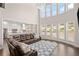 Bright living room boasting a wall of windows, hardwood floors, an open floorplan, and a modern light fixture at 11620 Crestview Ter, Johns Creek, GA 30024