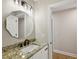 Bathroom with granite countertops, white cabinetry, modern fixtures, and a framed mirror at 1431 Brandy Shoals Se Ct, Conyers, GA 30013