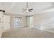 Spacious bedroom with neutral walls, carpet, ceiling fan, and access to a bathroom with sliding barn door at 1431 Brandy Shoals Se Ct, Conyers, GA 30013