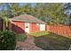 Detached red garage with a fenced yard providing parking and secure storage at 1431 Brandy Shoals Se Ct, Conyers, GA 30013