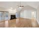Open living room with fireplace, ceiling fan, wood floors, and natural light from the windows and door to the backyard at 1431 Brandy Shoals Se Ct, Conyers, GA 30013