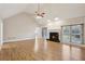 Bright living room featuring vaulted ceiling, fireplace, modern ceiling fan, and wood floors, creating a cozy and inviting space at 1431 Brandy Shoals Se Ct, Conyers, GA 30013